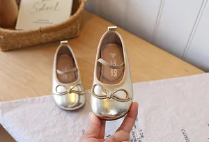 Detailed view of gold metallic girls' princess shoes with elegant bow and elastic strap