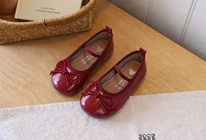 Macro view of wine red girls' patent leather princess shoes with elegant bow detailing