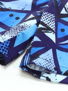 Gros plan d'un short de bain séchage rapide pour garçon avec motif géométrique bleu.