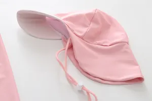 Gedetailleerd beeld van een roze kinderzwemmuts met een lange beschermende nekflap