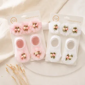 Detalle de conjunto de diadema y calcetines para bebé con flores de gasa suaves