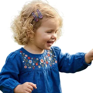Close-up of cute floral printed BB hair clips on a little girl's curly blonde hair