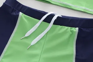 Close-up of boys' swim trunks waist with white drawstring and flatlock stitching.