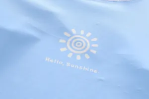Close-up of quick-dry blue kids' swimwear featuring a white sun and Hello Sunshine print