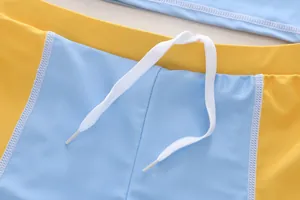 Detail shot of boys' quick-dry swimwear with adjustable white drawstring and yellow blue color-block