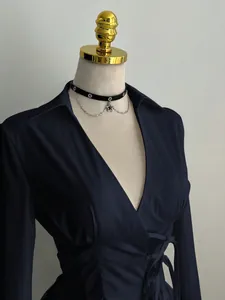Detail view of navy blue wrap shirt with deep V-neck and waist-tie design