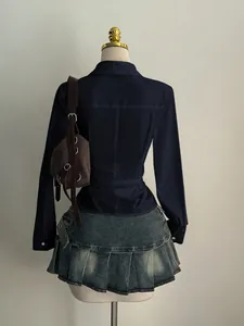 Detailed back view of a dark blue waist-cinching shirt with a pleated denim mini skirt