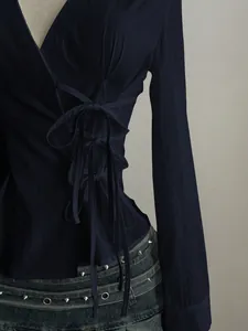 Detailed view of navy blue shirt with side lace-up design and waist-defining fit