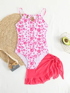 Detail view of a floral one-piece swimsuit for girls with matching pink mesh skirt