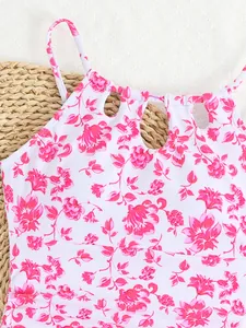 Detailed view of girls' white and pink floral one-piece swimsuit with chic cutout neckline