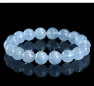 Detailed close-up of natural light blue aquamarine gemstone beads bracelet on black background