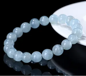 Macro close-up of natural light blue aquamarine round bead bracelet with glossy reflection