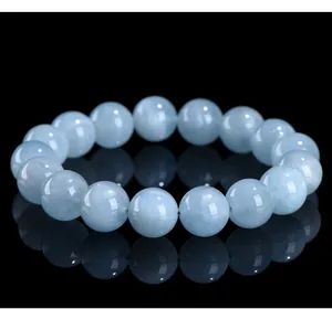 Close-up of natural star aquamarine round bead bracelet on reflective black surface