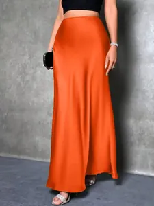 Detail eines eleganten orangefarbenen Satin-Maxirocks mit glänzender, glatter Textur