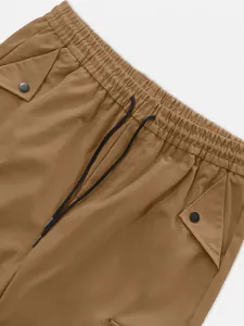 Dettaglio dell'elastico in vita e della coulisse dei pantaloni cargo tattici marroni