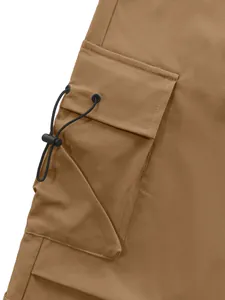Dettaglio macro della tasca cargo laterale con coulisse regolabile su pantaloni marroni