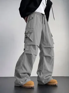 Vista dettagliata dei pantaloni cargo parachute grigi techwear con tasche laterali multiple