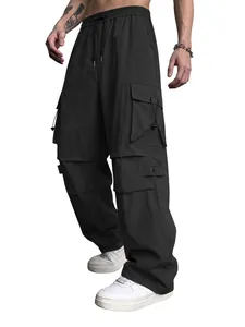 Macro view of black functional parachute cargo pants featuring multiple utility pockets