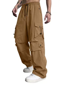 Detailed view of men's brown technical cargo pants with multiple tactical pockets and drawstring