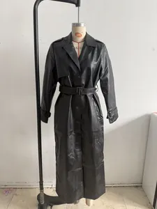 Elegant long black faux leather trench coat for women with waist belt and lapels