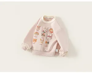 Dettaglio felpa rosa da bambina con stampe di animali e decorazioni di pupazzi 3D