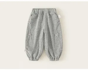 Pantaloni jogger grigi per bambini con graziosi fiocchi decorativi sulle cuciture