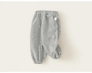 Dettaglio pantaloni sportivi grigi per bambina con fiocchi laterali e vita elasticizzata