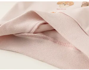 Primo piano di una felpa rosa da bambina che mostra il polsino a coste e il tessuto