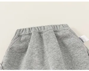 Dettaglio ravvicinato dell'elastico in vita grigio e della tasca per pantaloni da bimbo