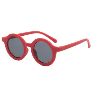 Detail view of classic round red matte frame sunglasses for kids with grey tinted lenses