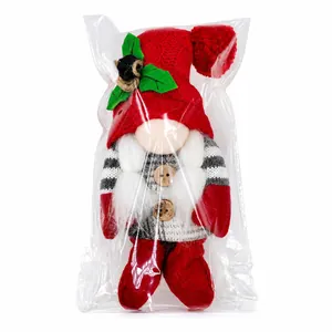 Detail eines Weihnachtsgnoms Plüsch mit roter Strickmütze in Klarsichtverpackung.