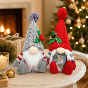 Ein Paar festliche Weihnachtswichtel mit Strickmützen und Dekorationen auf einem Tisch.