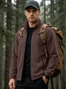 Scatto lifestyle all'aperto di un uomo con una giacca in pile marrone con zip nel bosco