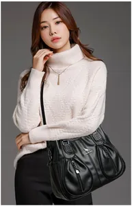 Professional model carrying a black textured leather shoulder bag with kangaroo logo detail