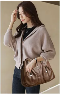 Detailed view of a brown textured leather shoulder bag for women worn by a model