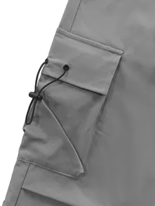 Close-up of utility pocket and adjustable drawstring on grey techwear cargo pants