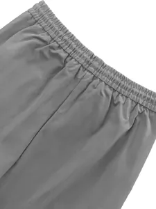 Macro view of the elastic waistband on men's grey parachute cargo pants for casual wear