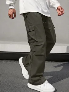 Detailed view of men's olive green wide-leg parachute cargo pants with side pockets