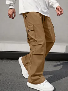 Detailed side view of men's loose parachute techwear cargo pants in a khaki brown shade