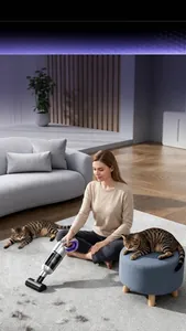 Portable electric pet hair vacuum cleaner removing cat fur on a white carpet in living room