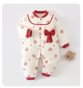 Detailed view of baby cotton romper with red bow and traditional patterns.