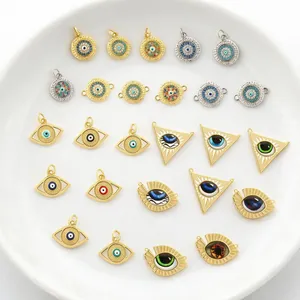 Detail view of gold-plated evil eye charms with colorful enamel and zircon for DIY jewelry.