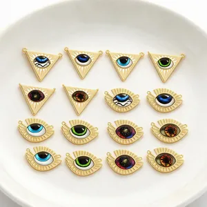 Detailed view of various gold-plated evil eye pendants with enamel centers for jewelry DIY.