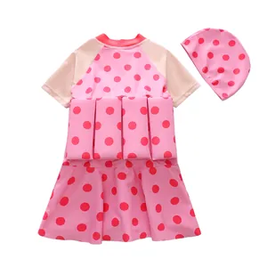 Detailed view of pink polka dot kids buoyancy swimsuit set with matching cap