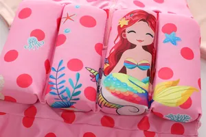 Close-up detail of girls' pink buoyancy swimsuit featuring a cute cartoon mermaid and marine print