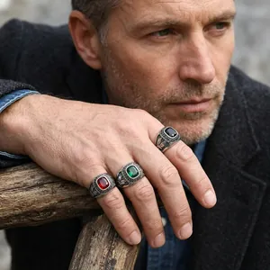 Detail shot of vintage punk rings with eagle engravings and colored gemstones.