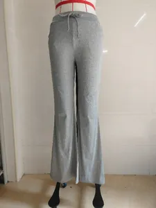 Grey flared yoga pants with adjustable drawstring waist shown on a mannequin display
