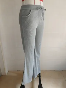 Detailed view of grey flared yoga trousers with drawstring waist on mannequin