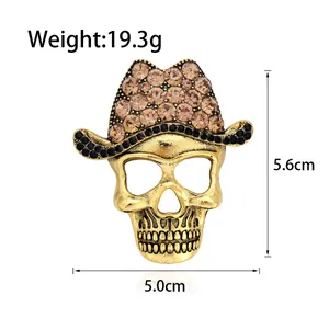 Vintage gold skull brooch with rhinestones and cowboy hat detail, measures 5.6cm by 5.0cm