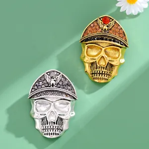Detailed macro view of rhinestone-encrusted skull brooches in gold and silver finishes